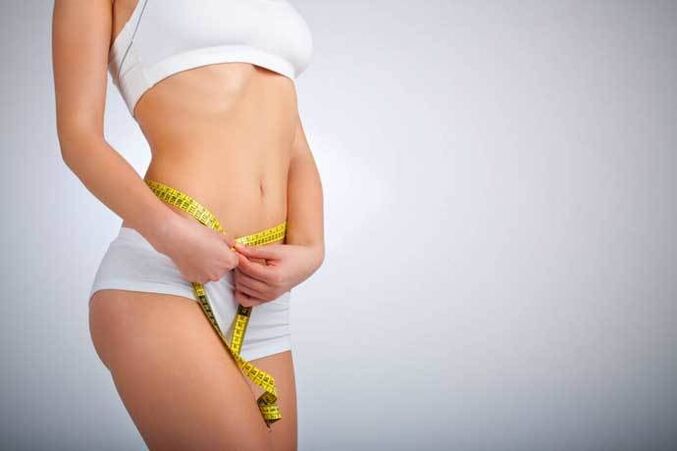 Slim girl measures the waist volume